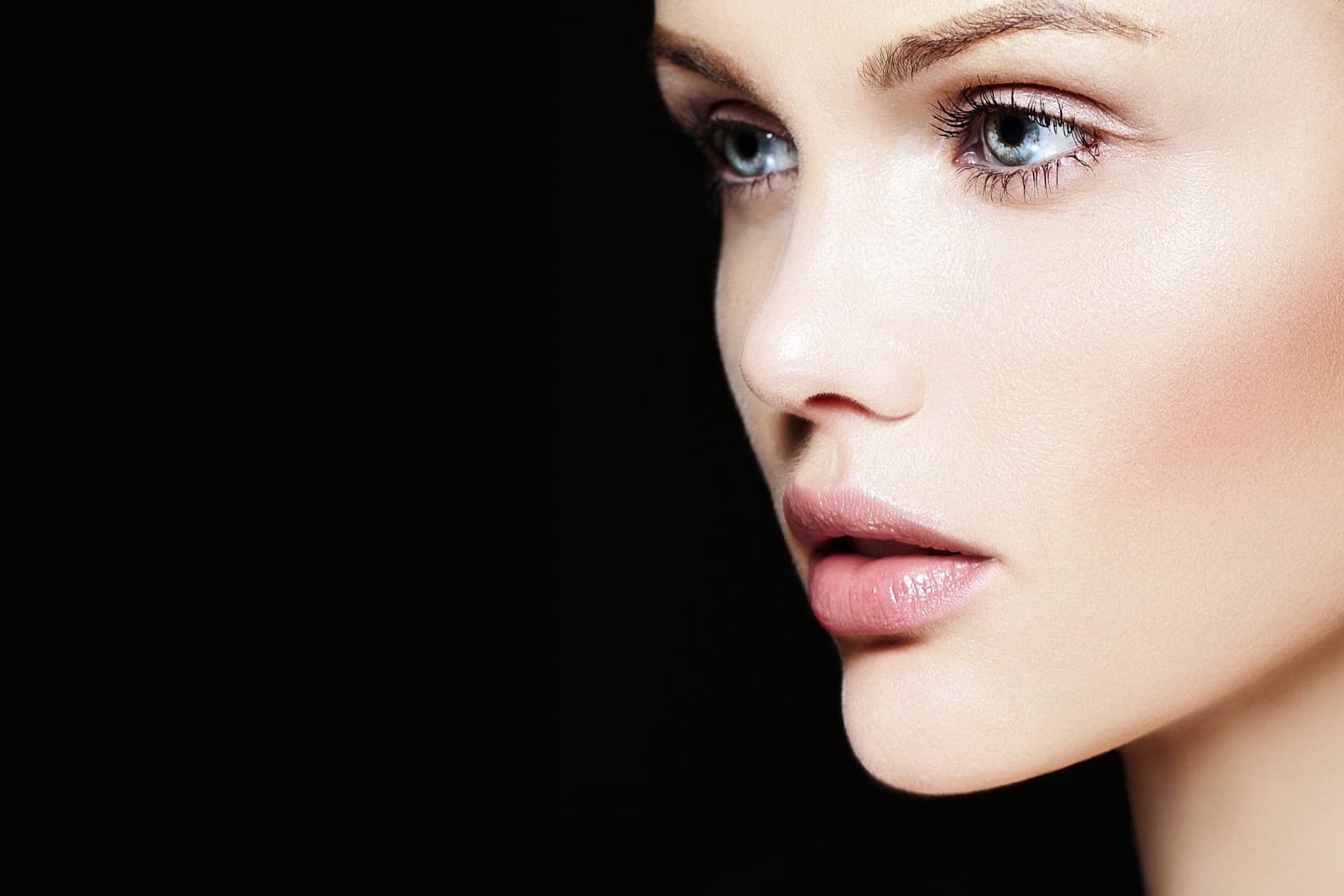 Rostro de mujer joven bella tres cuartos con fondo negro