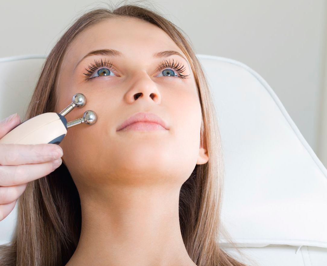 mujer que tiene un tratamiento facial estimulante de un terapeuta