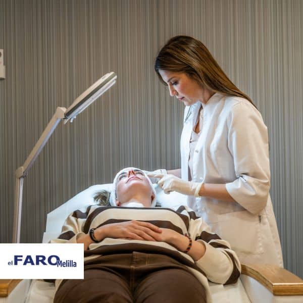 Imagen correspondiente a un artículo de El Faro de Melilla donde aparece la Dra. Graziella Moraes realizando un diagnóstico a una paciente tumbada en una camilla
