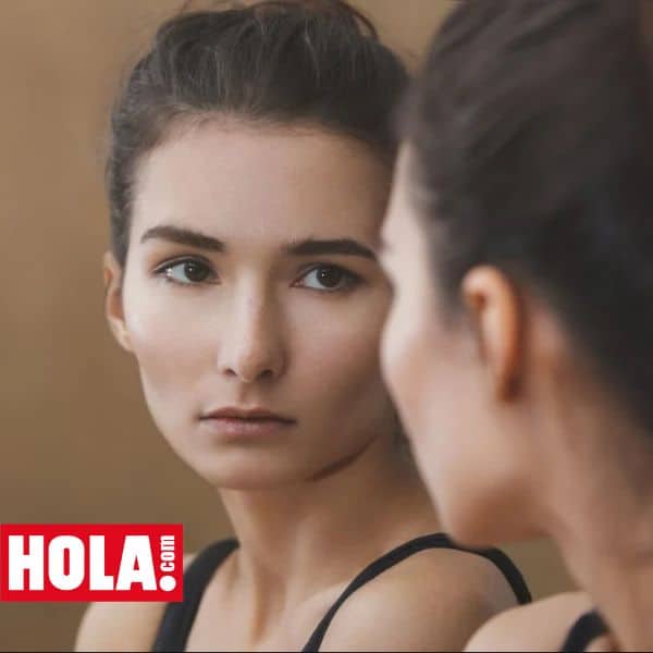Imagen correspondiente a un artículo de la revista Hola! donde aparece el reflejo en el espejo de una joven morena con expresión preocupada