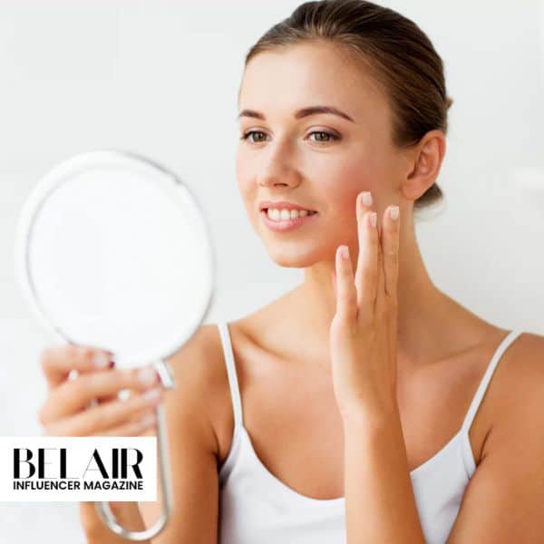 Imagen correspondiente a un artículo de la revista Belair donde aparece una mujer joven apreciando su piel en un espejo