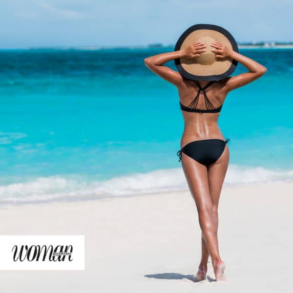 Imagen correspondiente a un artículo de la revista Woman donde aparece una mujer esbelta de espaldas en la playa sin ningún tipo de imperfección en su piel