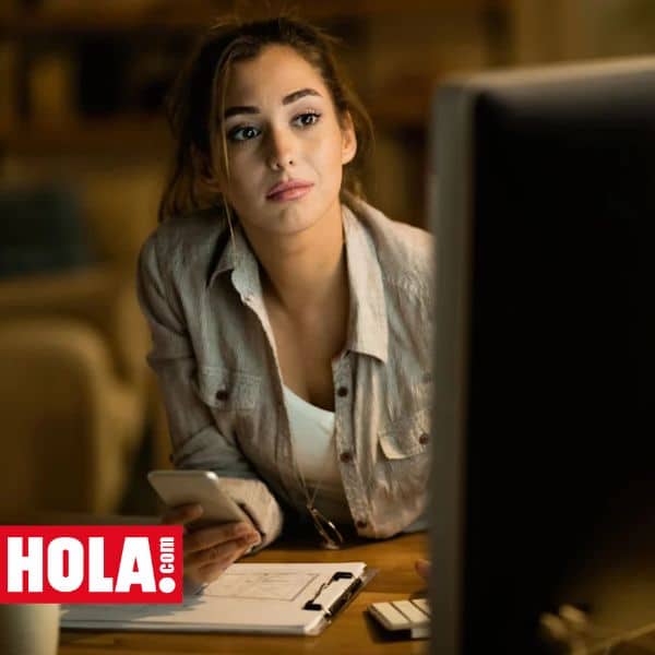 Imagen correspondiente a un artículo de Hola.com donde una mujer joven trabaja frente a un ordenador y la luz de este le ilumina el rostro