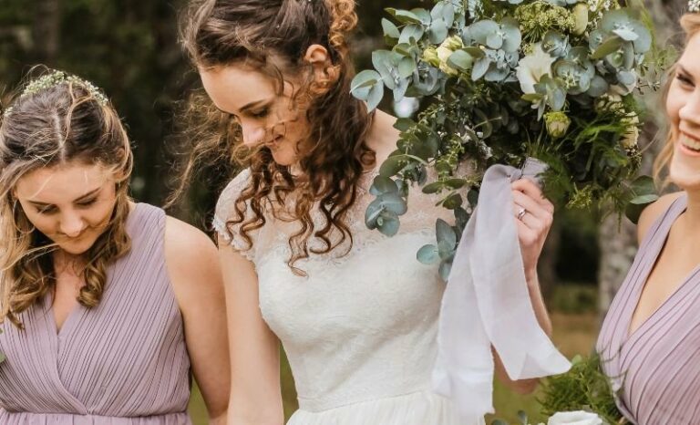 Novia joven acompañada de dos damas de honor el día de su boda, todas con las pieles perfectas